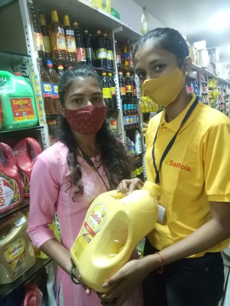 Assisted-selling team demonstrating a bulk oil pack in modern trade